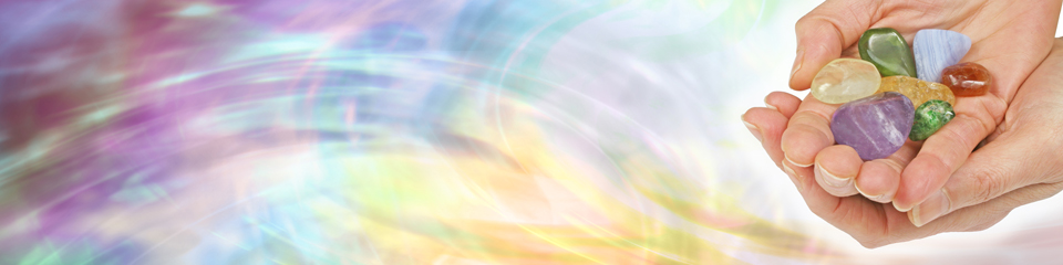 Colorful background with hands holding colorful gemstones.