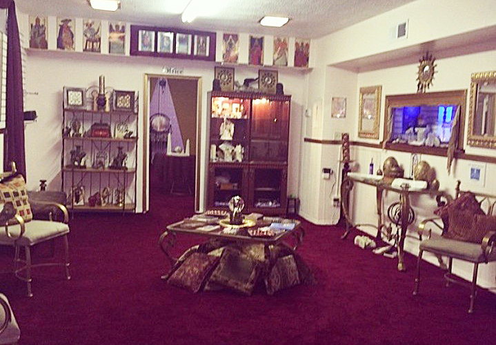 Psychic Vivian Tyson's office showing a table with crystal ball, shelves with decorations related to psychics.